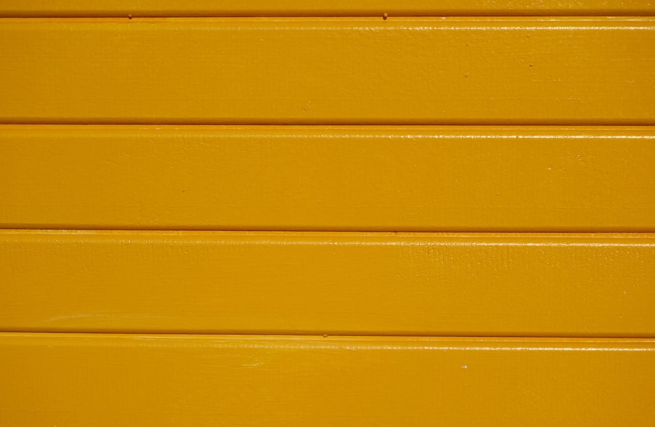 Close-up of yellow painted wooden planks with a clear textured finish.